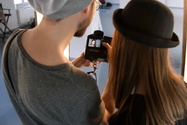 Fotógrafo y modelo viendo fotos en cámara — Foto de Stock