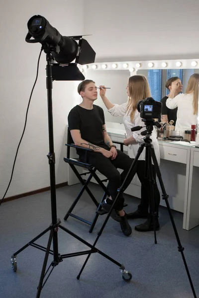 Mujer aplicando maquillaje masculino — Foto de Stock