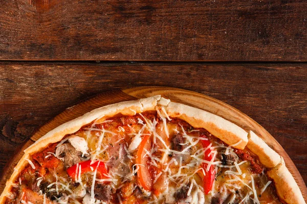 Горячая пицца подается на деревянном столе с бесплатным местом — стоковое фото