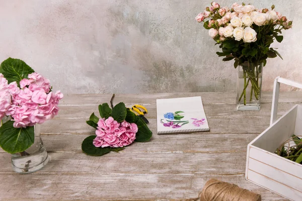 Lugar de trabajo con flores, ramo y boceto — Foto de Stock