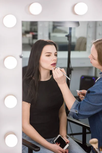 Maquillaje artista poner lápiz labial en la mujer — Foto de Stock