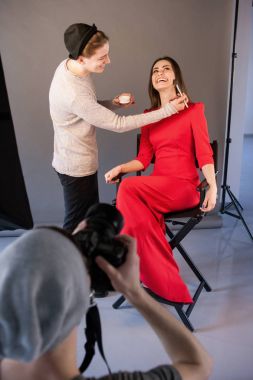 Visagist mutlu kadın Photoshoot için makyaj yapmak