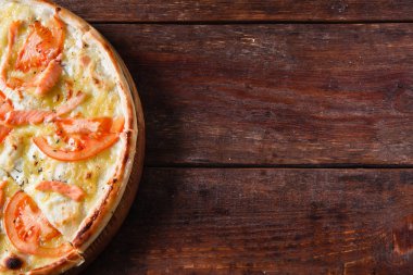 Pişmiş pizza domates ve somon ile düz yatıyordu