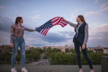 İki öğrenci tutan Amerikan bayraklı