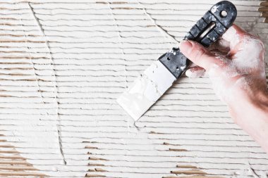 Spatula çalışmaları ile beyaz sıva ile el, onarım.