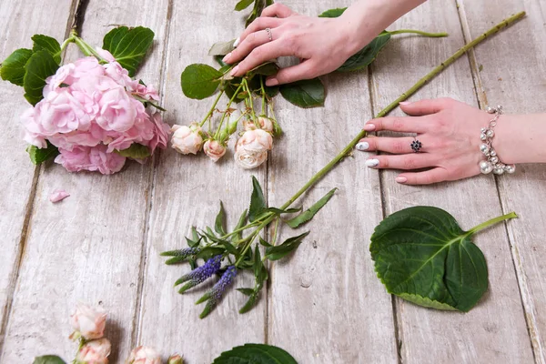 Lugar de trabajo con flores. Manos de florista — Foto de Stock