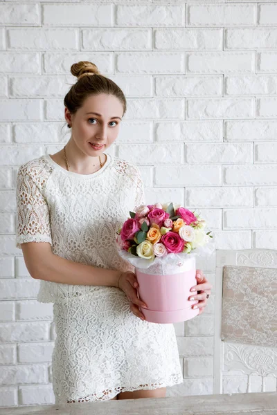 Femme élégante avec un cadeau. Bouquet de fleurs de luxe — Photo