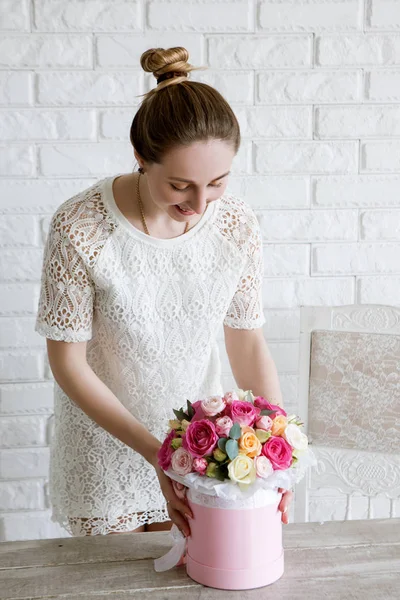 Femme élégante avec un cadeau. Bouquet de fleurs de luxe — Photo