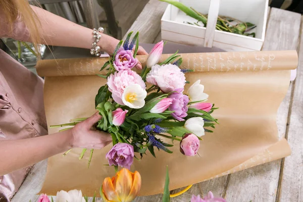 Woman have pack tulip bouquet in wrapping paper