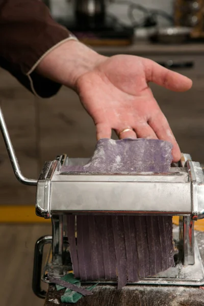 Главный с макаронами машина делает фиолетовое тесто — стоковое фото
