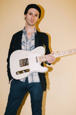 Yetişkin erkek hipster elektro gitar ile poz