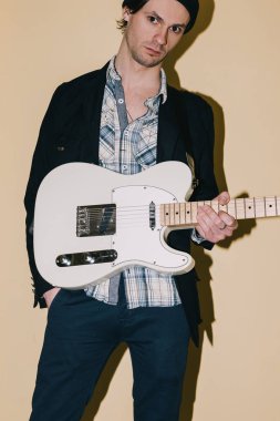 Erkek hipster elektro gitar closeup ile poz