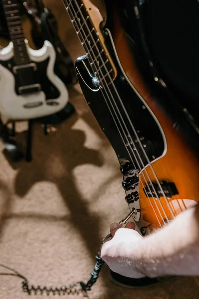 Гитарист, соединяющий бас-гитару в студии — стоковое фото