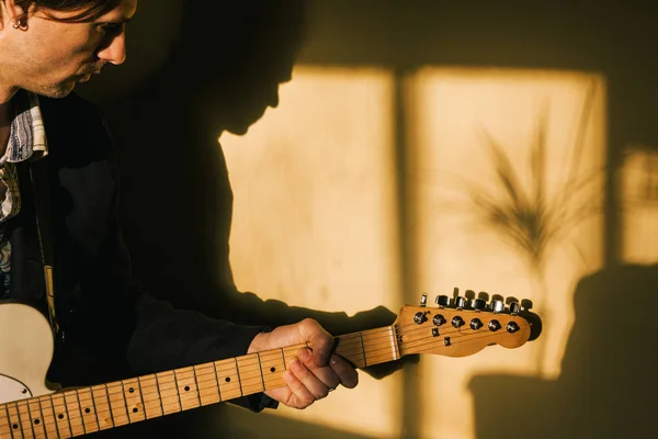 Гитарист с электрогитарой играет дома — стоковое фото