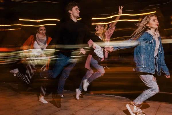 Μετακίνηση νεολαίας στην πόλη του το βράδυ. Θολή φόντο — Φωτογραφία Αρχείου