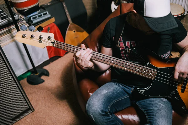 Bas gitarist garaj üst görünümünde gitar çalmak