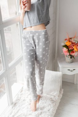 Şehvetli genç kadın yakınındaki pencere eşiğinde kalıyor