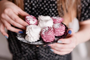 Genç kadın renkli tatlı zephyrs yiyor