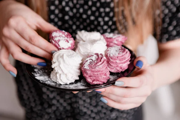 Genç kadın renkli tatlı zephyrs yiyor