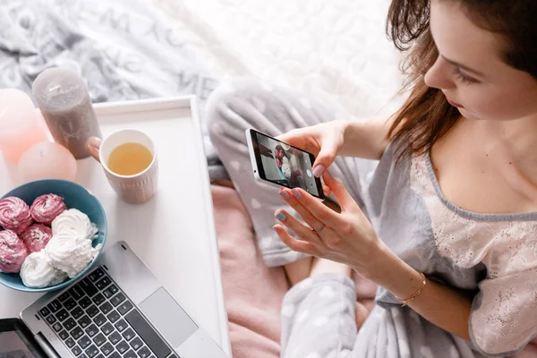 Jonge vrouw maakt foto van snoep door smartphone — Stockfoto