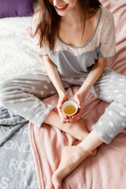 Neşeli genç kadın, şefkatle çay tutar