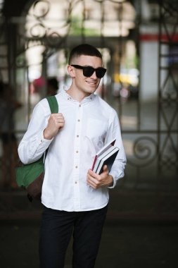 Genç şık öğrenci açık havada. Modern gençlik