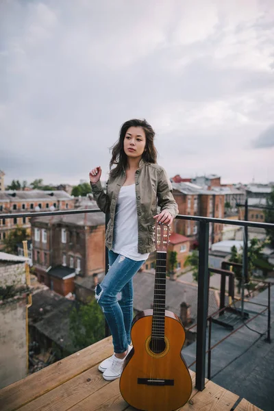 Уличная музыка. Молодая девушка с акустической гитарой — стоковое фото