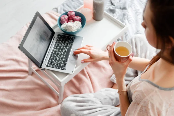 Ung kvinna som arbetar på laptop på morgonen — Stockfoto