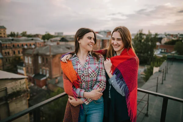 Пара усміхнених дівчат, що зупиняються на міському тлі — стокове фото