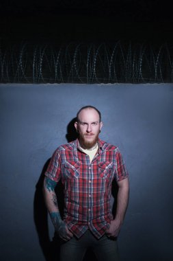 Kendine güvenen hippi erkek dikenli tel zemin üzerine