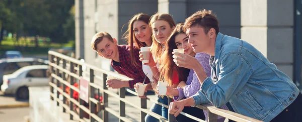 Estudiantes disfrutando de una taza de café para salir a la calle . — Foto de Stock
