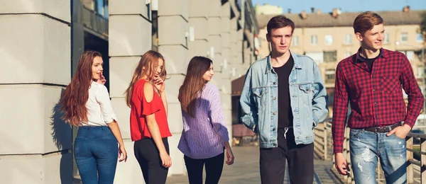 Gruppe junger Frauen flirtet mit Männern in der Stadt. — Stockfoto