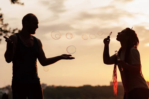 Couple bubble blowing silhouette nature concept. — Stock Photo, Image