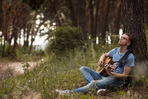 Homem pensativo tocando guitarra conceito floresta . — Fotografia de Stock