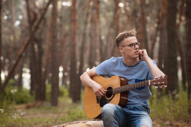 Gitarist adam görüşmeler orman konsept telefon.