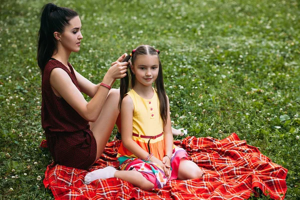 Μικρό κορίτσι μητέρα χτένισμα picnic χαλαρώσετε έννοια — Φωτογραφία Αρχείου