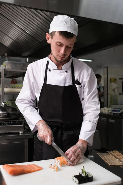 Chef cutting sushi rolls asian cuisine — Stock Photo, Image