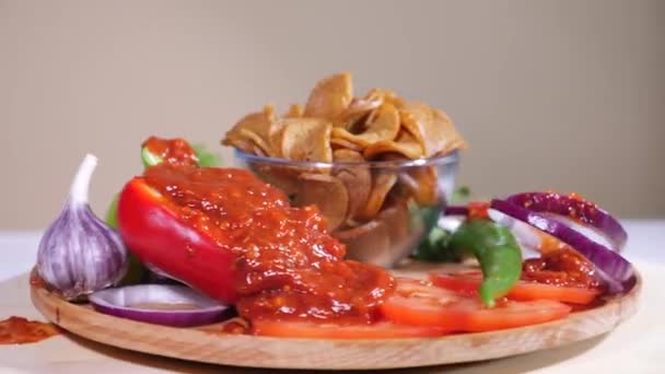 Вкусные хлебные крекеры с луком, перцем и томатным соусом на деревянной тарелке — стоковое видео