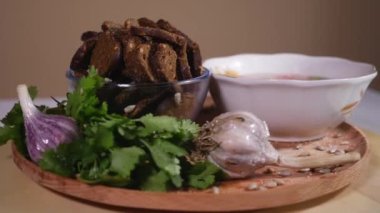 Tahta tabakta tavuk çorbası, ekmek krakeri ve sebze.