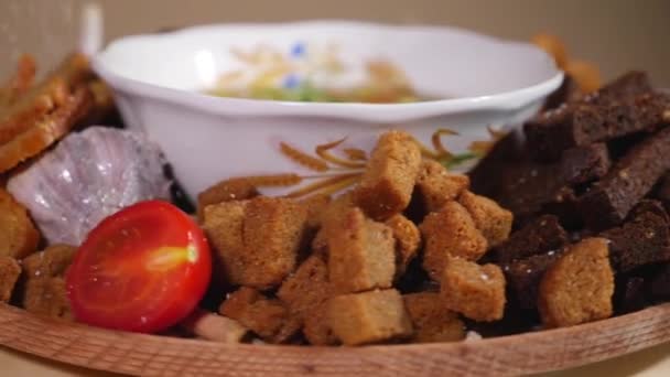 Rotating plate with bowl of soup, bread crackers and fresh vegetables — Stock Video