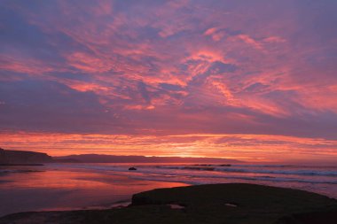 Dalgalar ile plaj güneş doğarken