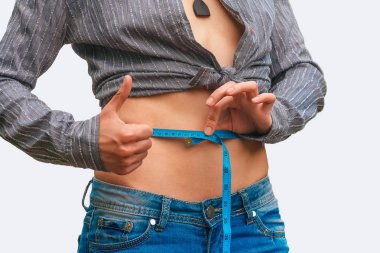 Belini ölçen genç bir kadın. 