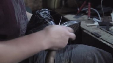 Shoemaker is repairing shoes. Close-up