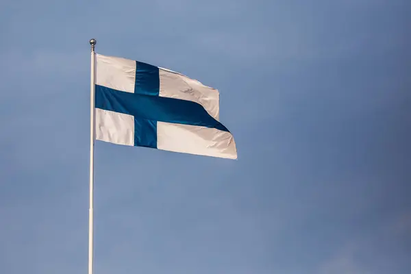 Bandera finlandesa contra el cielo azul soleado — Foto de Stock
