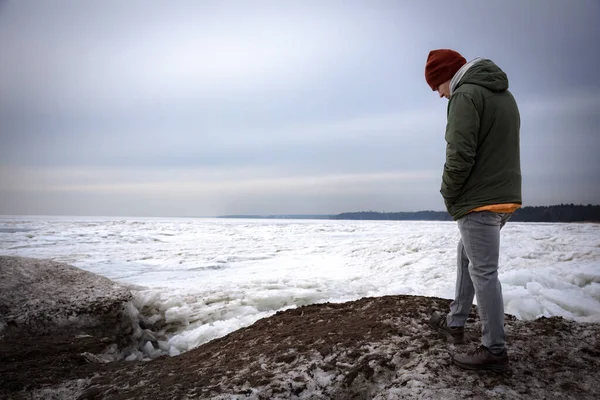 Retrato de um homem em um lago no inverno. O tipo de chapéu e casaco contra o gelo. — Fotografia de Stock