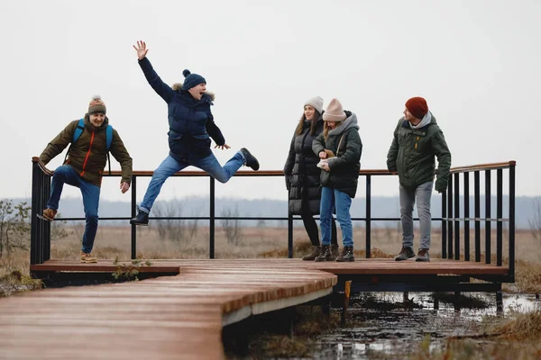 Cinci oameni sar. Compania prietenilor se relaxează în natură — Fotografie, imagine de stoc
