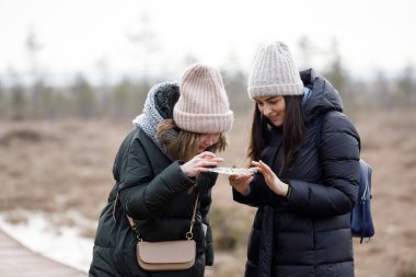 İki arkadaş ormanda yürür. Kızlar doğada rahatlar.