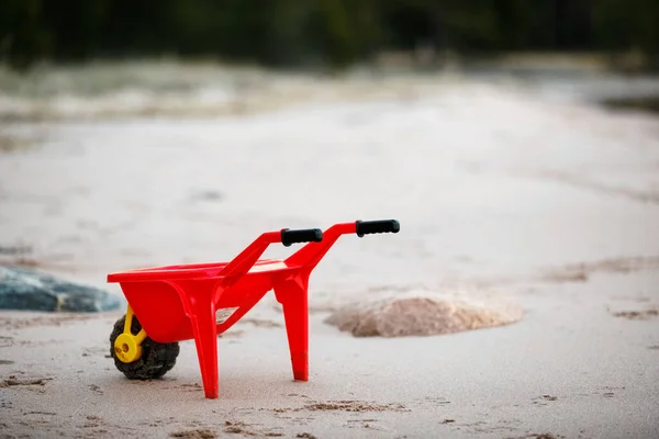 Červený vozík na pláži. Dětský vozík prázdný — Stock fotografie