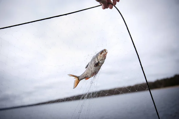 Primeros planos revisando la red de pesca en un barco. Percha en la red contra el cielo — Foto de Stock