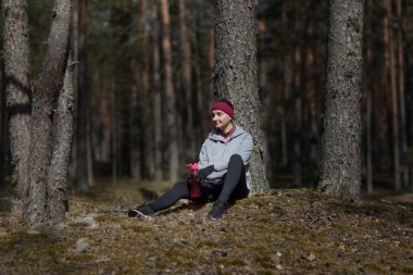 Ormandaki kız koşudan sonra su içiyor.